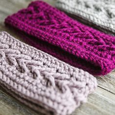 three crocheted headbands sitting on top of a wooden table