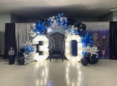 the balloon arch is decorated with blue and silver balloons that spell out the number 30