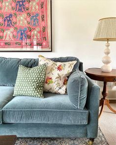 a living room with a blue couch and two lamps