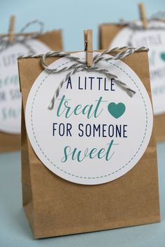 two small brown bags with tags on them that say, a little treat for someone sweet