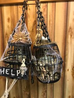 two cages with skeleton decorations hanging from them