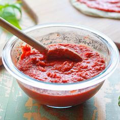 a bowl filled with sauce on top of a wooden table