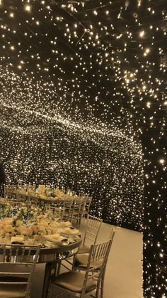 a large table with many chairs and lights on the ceiling above it is set up for a formal function