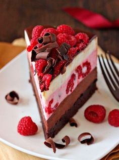 a piece of cake with raspberries and chocolate on top