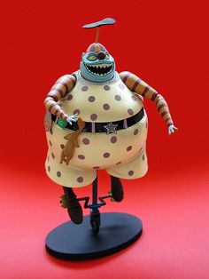 a figurine that is on top of a black stand with polka dot dots