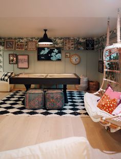 a living room with a pool table and lots of pictures on the wall behind it