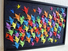 colorful origami birds are arranged on a black frame