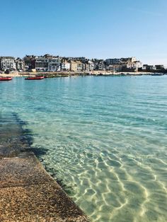 the water is crystal clear and there are boats in it