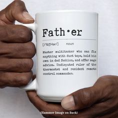 a person holding a white coffee mug with the words father printed on it in front of their hands