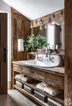 a rustic bathroom with wooden walls and drawers