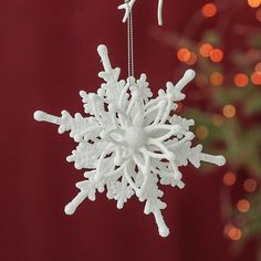 a snowflake ornament hanging from a christmas tree