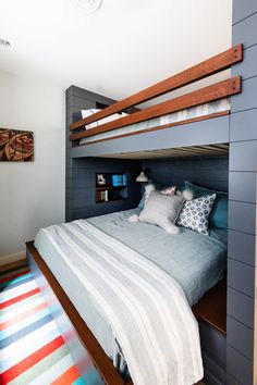 a bedroom with a bunk bed and striped rug