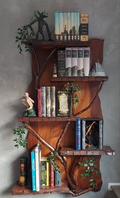 a book shelf with books on top of it and a tree branch hanging from the wall