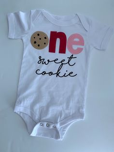 a white onesie with the words one sweet cookie on it and a chocolate chip cookie