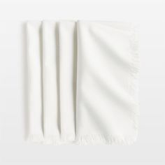 an image of a white towel folded on top of each other with fringes around the edges