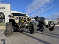 two jeeps are parked in front of a building