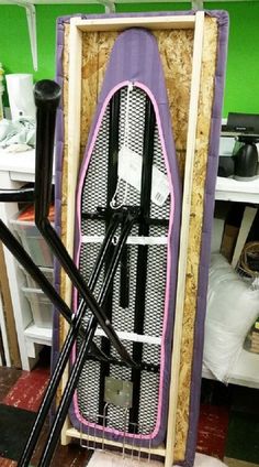 a purple and white surfboard sitting on top of a wooden stand in a room