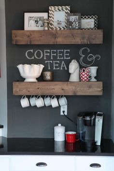 two wooden shelves with coffee cups on them and other kitchen items in front of the wall