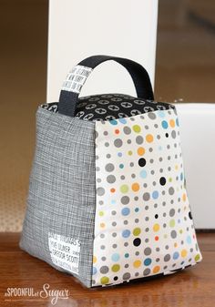 a bag sitting on top of a wooden table next to a white box with polka dots