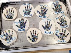 six handprints made out of rocks sitting on top of a cookie sheet with words rock's written on them