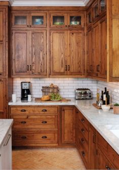 a kitchen with wooden cabinets and white marble counter tops, along with an appliance that reads houzz