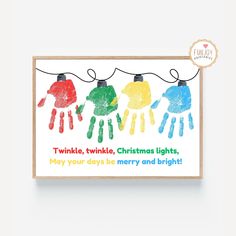 a christmas card with three children's handprints hanging from the clothes line