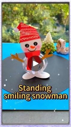 a snowman with a red hat and scarf standing on top of a black table