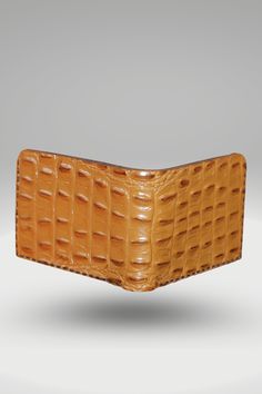 Men's Glossy Tan Brown Genuine Cowhide Leather Wallet With Crocodile Textured Finish | Bifold Hand-Made Leather Wallet This Hand-Made Men's Crocodile Leather Wallet combines sleek style and functionality to suit any occasion. It is the ultimate minimalist wallet, made with 100% vegetable-tanned leather and a 3D crocodile texture with a glossy tan-brown color finish. This men's leather wallet features two cash slots and two card pockets and a black interior with elegant stitching. Its edges are beveled, waxed, and burnished for a smooth finish. Style: Standard Bi-Fold Wallet Made: Hand-stitched using waxed polyamide thread Leather: 100% Vegetable Tanned Cowhide leather With 3D Crocodile Textured Finish OuterShell Color: Tan Brown InnerShell Color: Black Thread: Black Closure: Bi-fold Featur