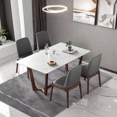 a dining room table with chairs and a rug on the floor in front of it