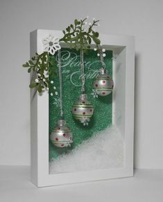 an ornament in a box with ornaments hanging from it