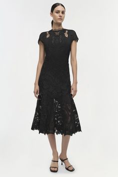 CORE COLLECTION Our Signature Laura Lace Appliqué Midi Dress in Black. Romantic and feminine, this cap sleeve midi dress is cut from delicate lace for a fluid silhouette. Framing the tiered skirt and v-neck back, subtle eyelet embroidery adds a final decorative flourish. A Simkhai signature. Also available in: White