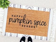 a door mat with the words happy pumpkin spice season on it next to a pair of black slippers