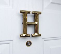 a close up of a door handle with the letter h on it's side