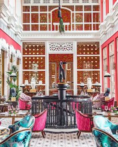 an ornately decorated lobby with pink and blue chairs