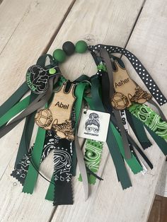 an assortment of green and black items are arranged on a wooden surface with tags attached to them