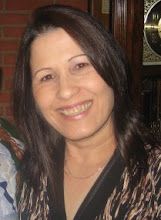 a woman smiling for the camera in front of a clock