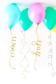 five balloons with the word happy written on them and some streamers attached to them