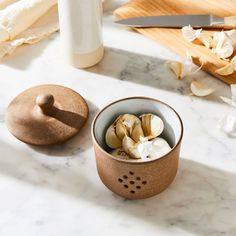 a wooden bowl filled with sliced bananas on top of a counter next to a knife