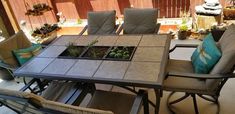 an outdoor table with chairs and plants on it