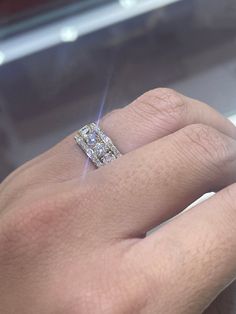 a person's hand with a diamond ring on it