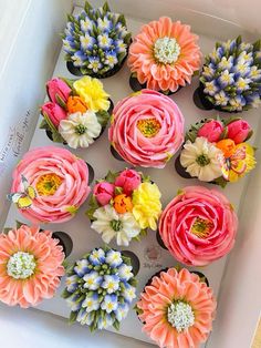 the cupcakes are decorated with colorful flowers