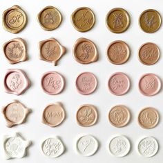 some different types of wax seals on a white surface with the letters and numbers engraved in them