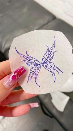 a hand holding a piece of paper with a butterfly on it