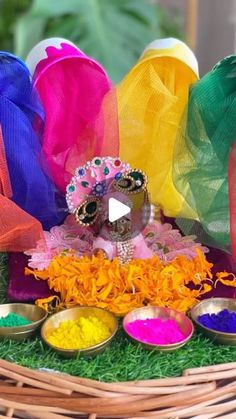 a basket filled with different colored powders next to two bowls full of colorful food