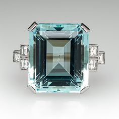 This fantastic vintage aquamarine ring is centered with one (1) emerald cut natural aquamarine set into a four-prong setting. The shoulders of the ring are each accented with three (3), bezel set, square step cut diamonds, bordered with milgrain edging. The ring measures 18.5mm at the top, rises 11.4mm above the finger, tapering to 2.2mm wide and 1.0mm thick at the base of the shank. The ring is currently a size 6.5. Luxury Emerald Cut Ring With Gemstone Accents, Modern Octagon Emerald Ring For Formal Occasions, Rectangular Emerald Ring With Accent Stones For Formal Events, Rectangular Emerald Ring With Accent Stones For Formal Occasions, Luxury Rectangular Diamond Ring With Accent Stones, Formal Aquamarine Diamond Ring With Prong Setting, Modern Topaz Ring With Rectangular Stone For Formal Occasions, Luxury Aquamarine Octagon Ring, Modern Formal Topaz Ring With Rectangular Stone