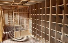 an unfinished room with wooden shelves and metal grates on the floor in front of it