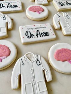 cookies decorated to look like doctors and brain images are on a table with congratulations dr astou written on them