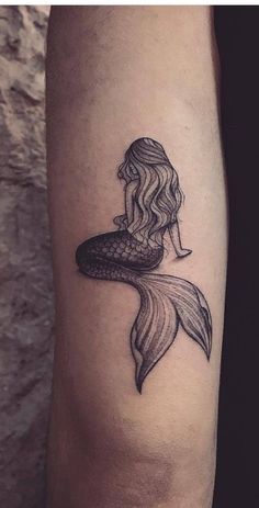 a woman's leg with a mermaid tattoo on it