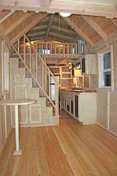 an open floor plan with stairs leading to the kitchen and living room in a tiny cabin