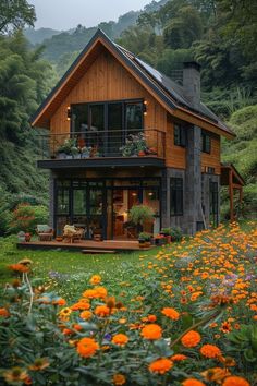 a house in the middle of some flowers and trees with lots of greenery around it